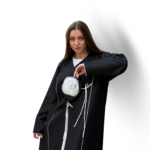 Model wearing a premium black abaya with white rose detailing and contrast piping – Muhajeerah